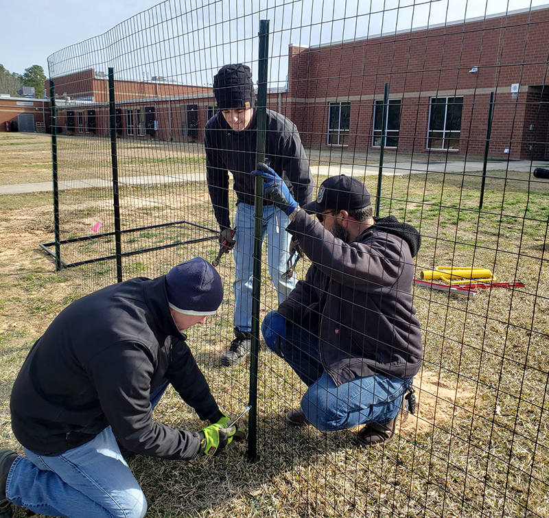 Volunteers installing the fencing at Heritage Elementary | Shaome Cooperative